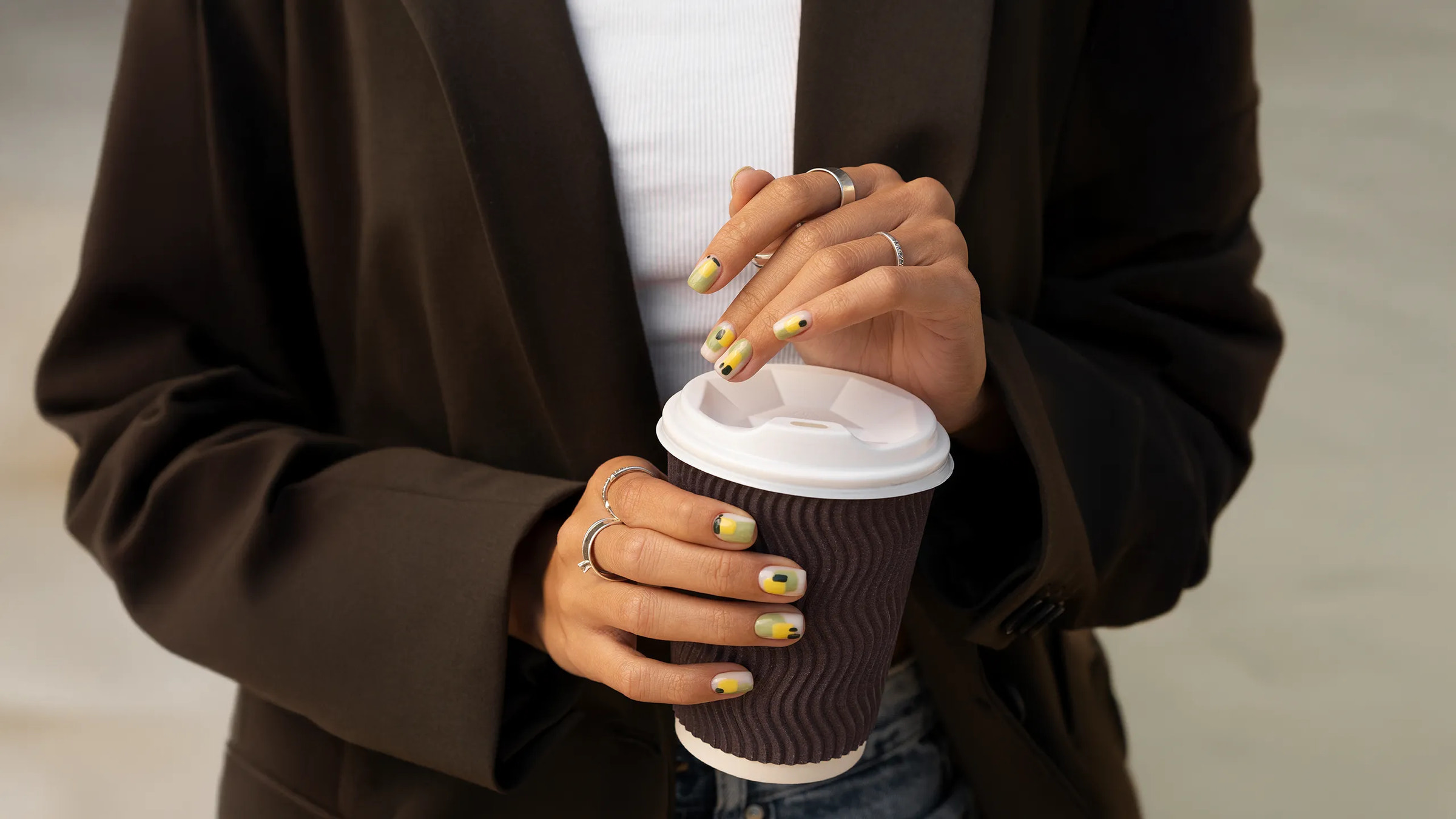 Women holding a brown coffee cup